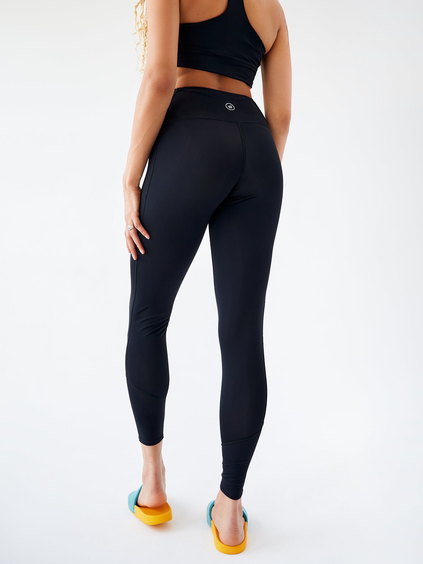 Legging noir écoresponsable, vue arrière, mettant en valeur la coupe ajustée et la taille sculptante.