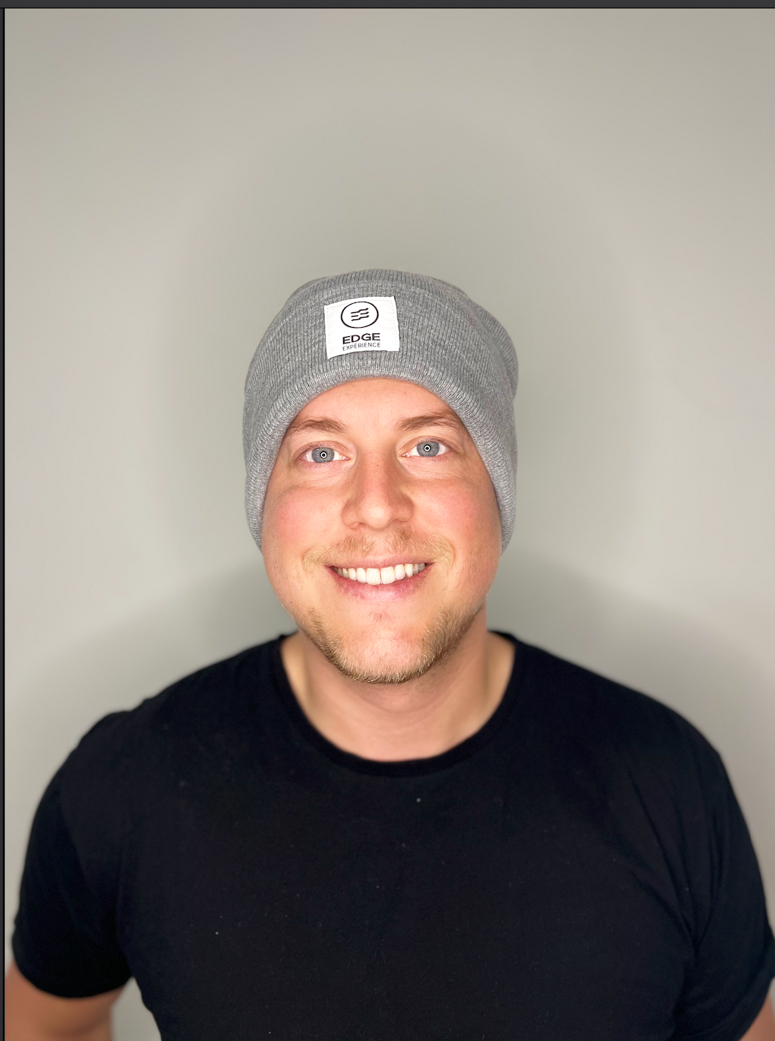 Tuque chinée grise en Polyana, vue de face, portée par un homme, offrant un design en tricot performant et durable, idéal pour la randonnée et la détente.