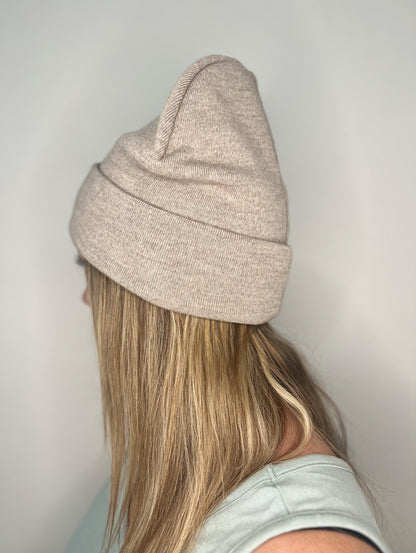 Tuque Earthy Explorer couleur Sand, vue de côté, portée par une femme, mettant en valeur la texture douce et le style intemporel.