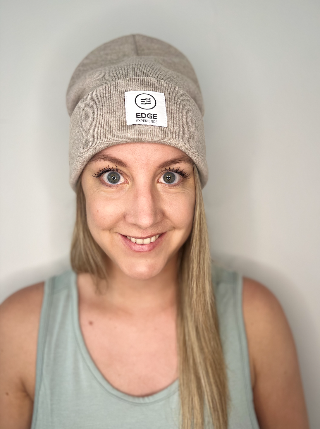 Tuque Earthy Explorer Sand avec square label, portée par une femme