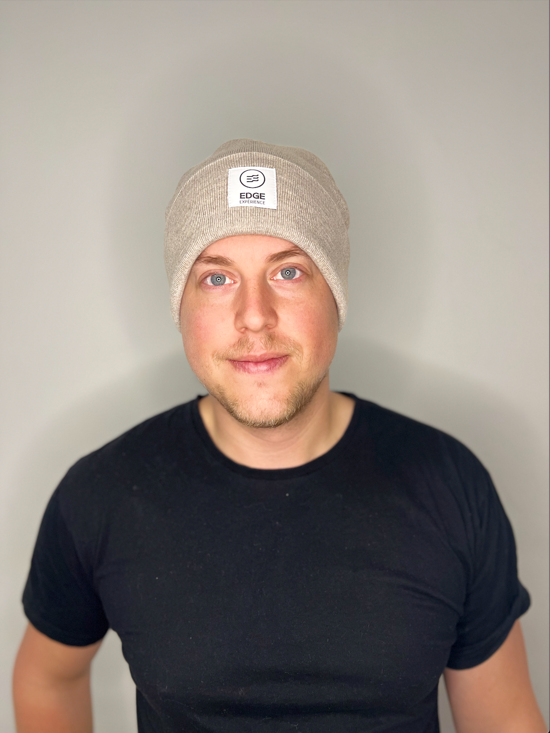 Tuque Earthy Explorer couleur Sand, vue de face, portée par un homme, avec design minimaliste et mélange de laine Mérinos extrafin et Dralon.