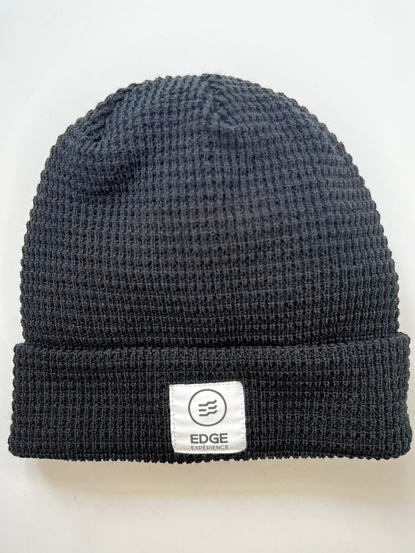 Tuque en tricot gaufré recyclée couleur noire, présentée seule, mettant en valeur son design gaufré élégant et son mélange de laine Mérinos et Dralon.