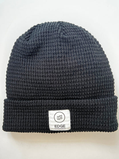 Tuque en tricot gaufré recyclée couleur noire, présentée seule, mettant en valeur son design gaufré élégant et son mélange de laine Mérinos et Dralon.