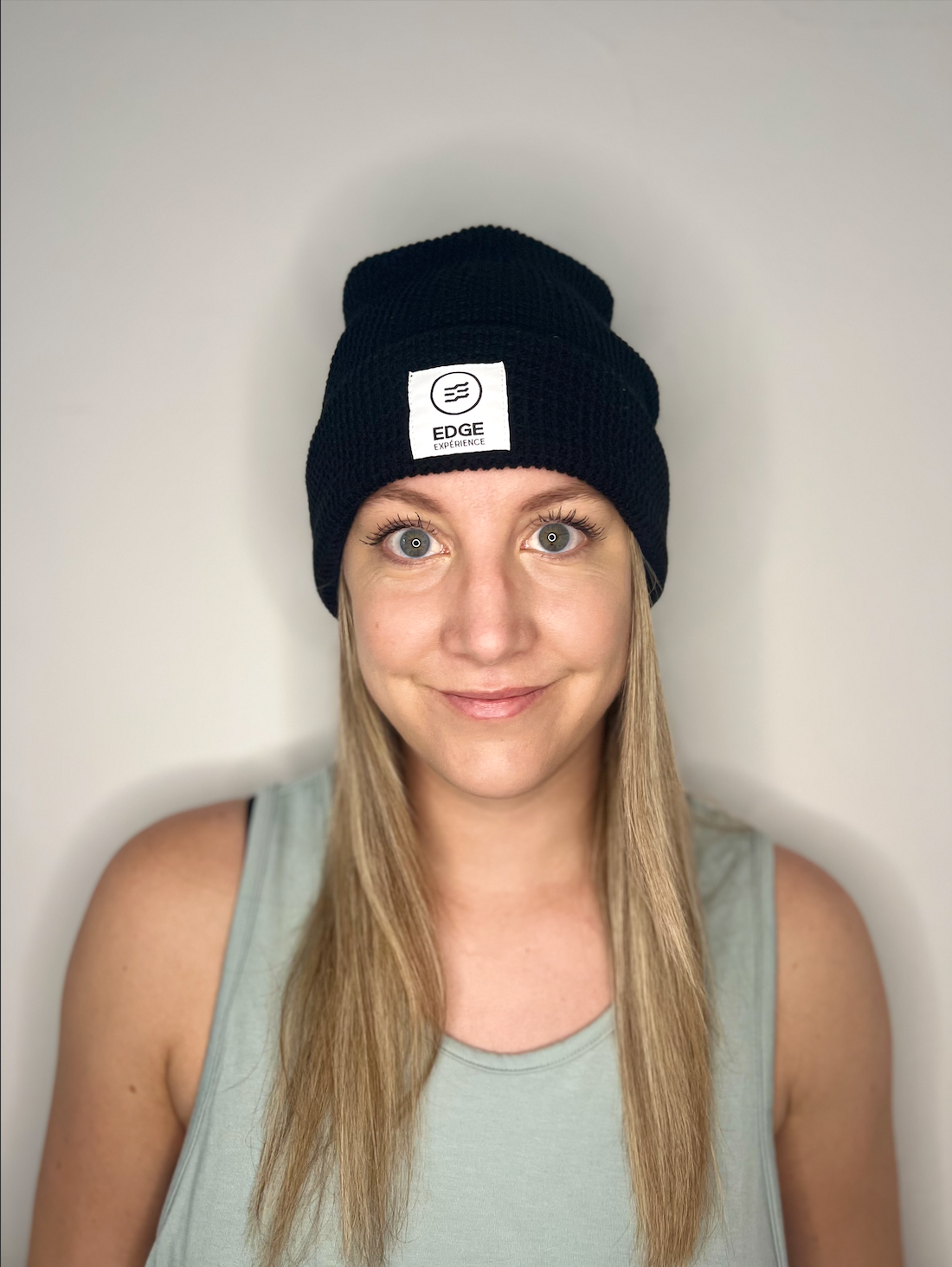 Tuque en tricot gaufré recyclée couleur noire, vue de face, portée par une femme, avec fit profil moyen et mélange durable de laine Mérinos extrafin et Dralon.