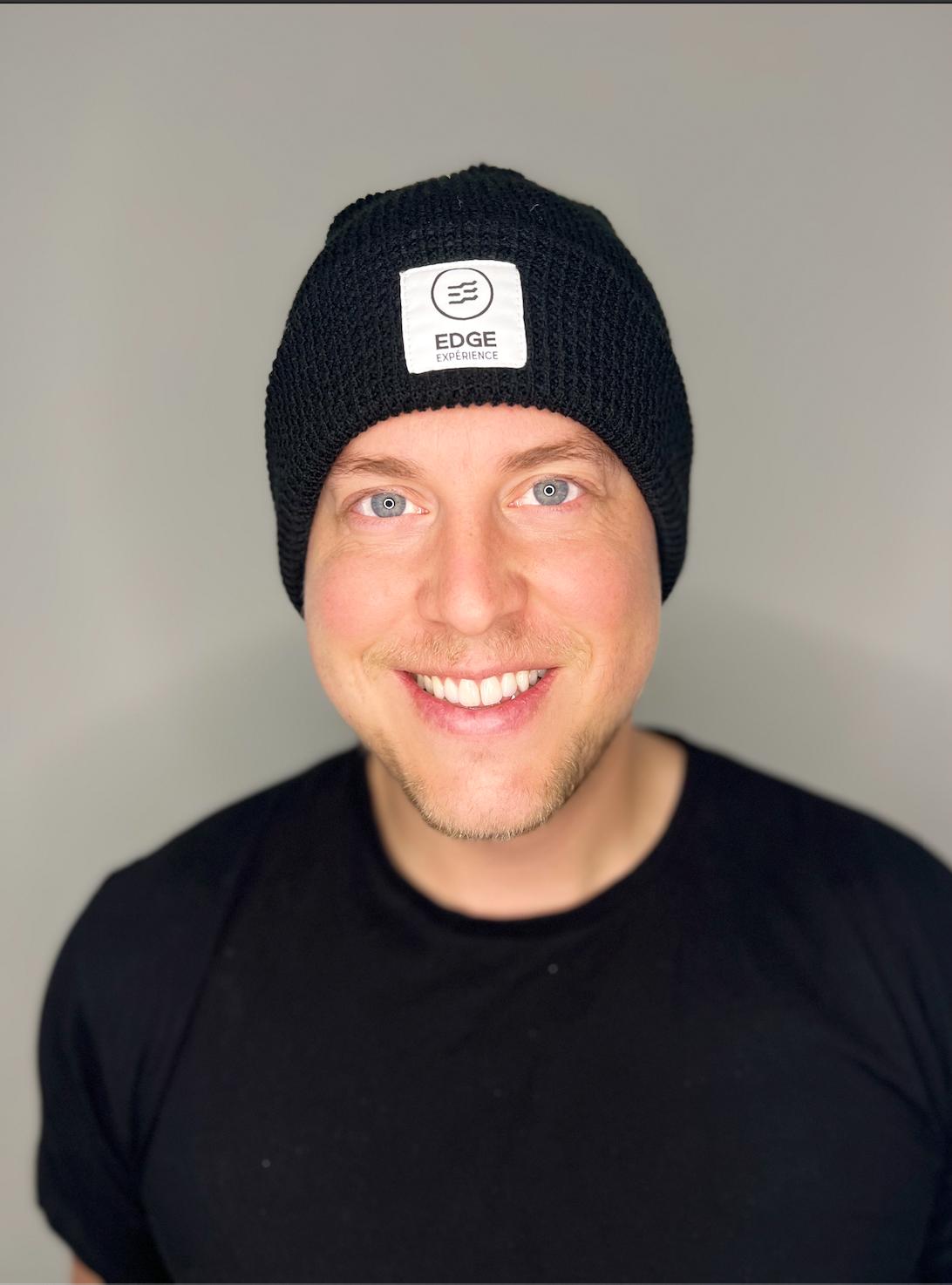 Tuque en tricot gaufré recyclée couleur noire, vue de face, portée par un homme, avec fit profil moyen et mélange durable de laine Mérinos extrafin et Dralon.